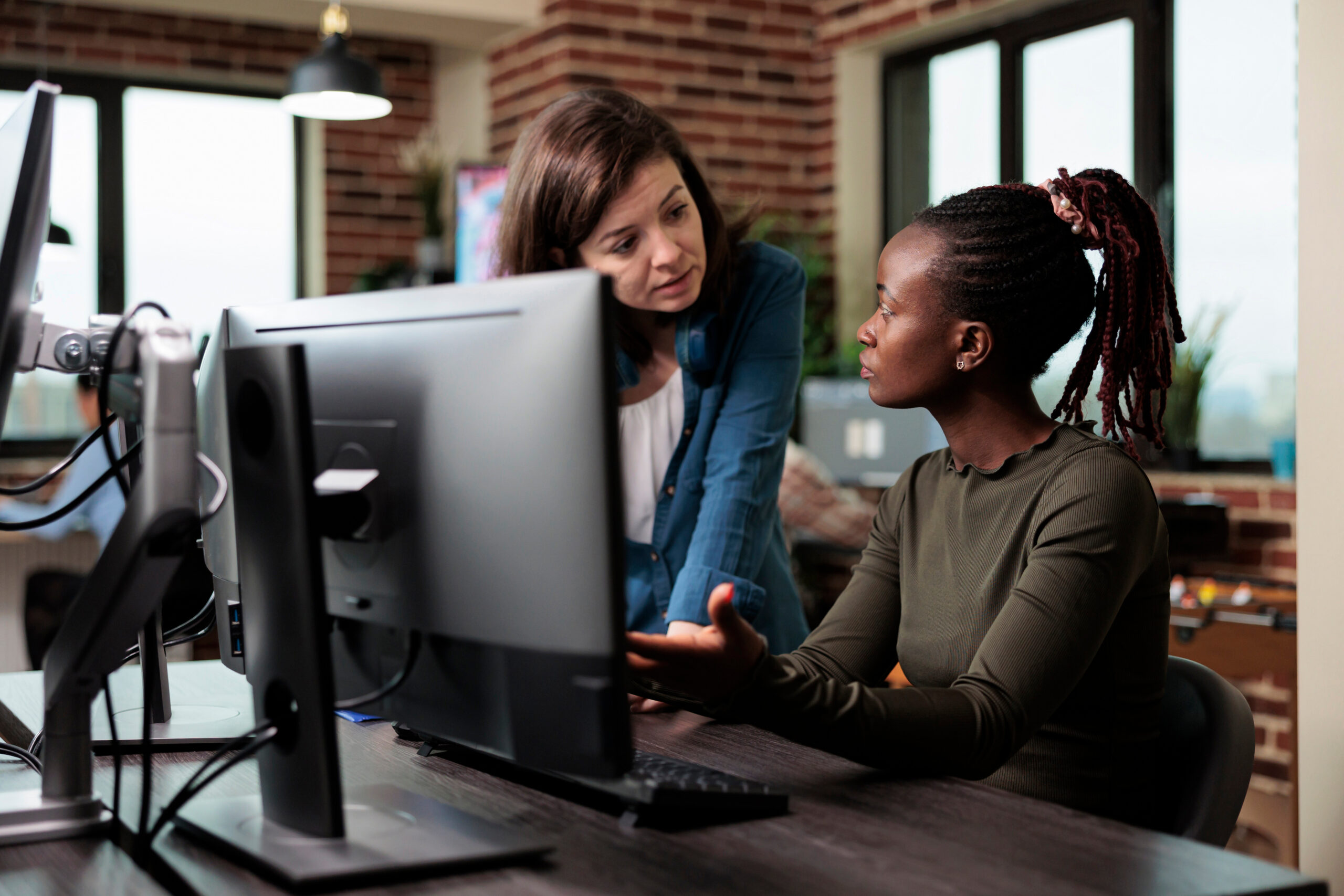 Two female members of staff discussing work at a computer screen in a GP surgery. AdobeStock_504072595 from Adobe stock photos from https://stock.adobe.com/uk/