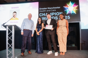 Image of GMPCB chair, Luvjit Kandula, presenting the collaboration award to the winner of the award. Mark Fisher is also in the photo along with the awards host, Mwaksy Mudenda