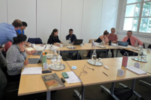 Group photo of some of the GP Peer Ambassadors at an event sat around a table