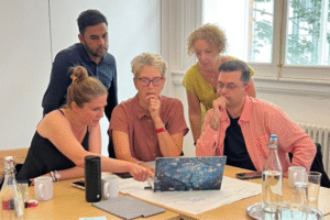 Image of delegates from Peer Ambassador day looking at a laptop.
